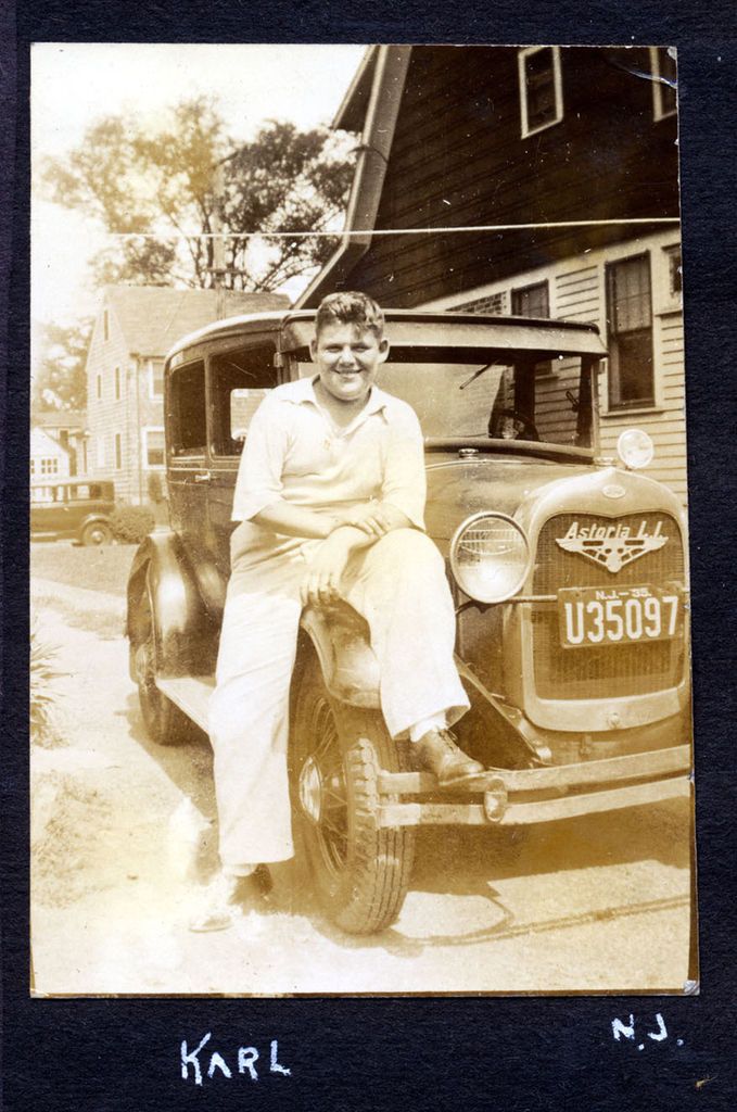 Man poses with 1930 Model A Ford, Large Astoria Dealer Plate on Grill