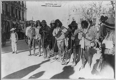 ,191 3 1914 poorly dressed Indians in a row with walking stick